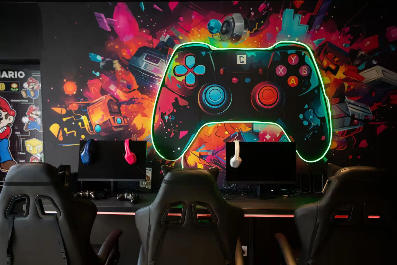 Salle gaming : manette néon géante et postes multijoueurs – gîte gaming Var